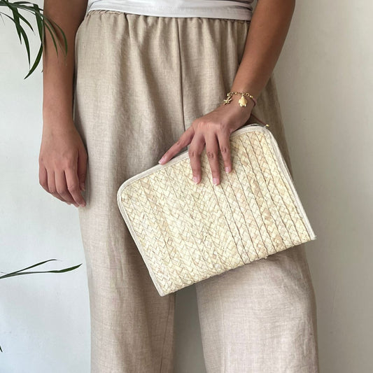Baseta palm pouch held flat at the hip by a woman in a neutral outfit, showing its size and shape — Khoos