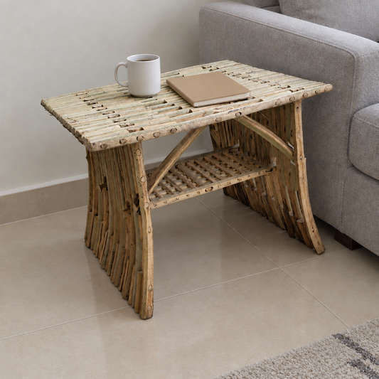 Al-Nakhaal palm midrib side table beside a grey sofa with a mug and notebook | Khoos