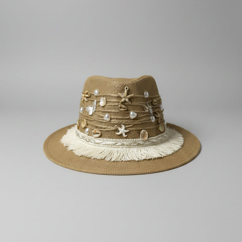 Brown straw hat with decorative elements on a white surface