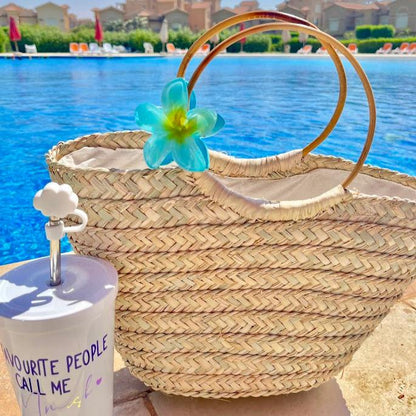 Boho Breeze basket styled poolside beside the water, bamboo handles catching the light — Khoos