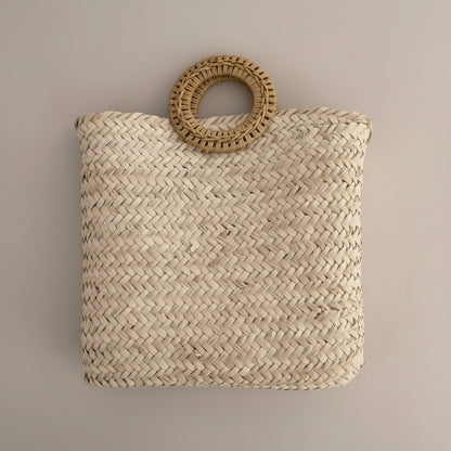 Woven palm clutch with rattan ring handle by Khoos