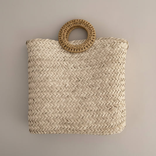 Woven palm clutch with rattan ring handle by Khoos