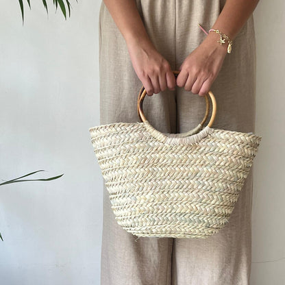 Boho Breeze basket packed with a striped beach towel and sunscreen on golden sand — Khoos