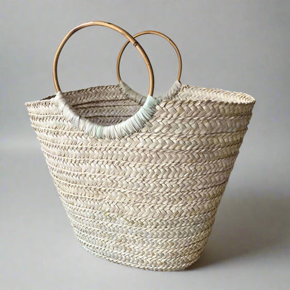 Boho Breeze large basket bag with bamboo circle handles, natural cream palm weave, on a grey studio backdrop — Khoos