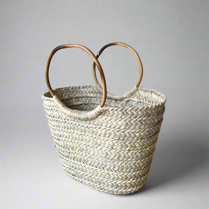 Boho Breeze basket carried against a cream linen outfit, showing scale — Khoos