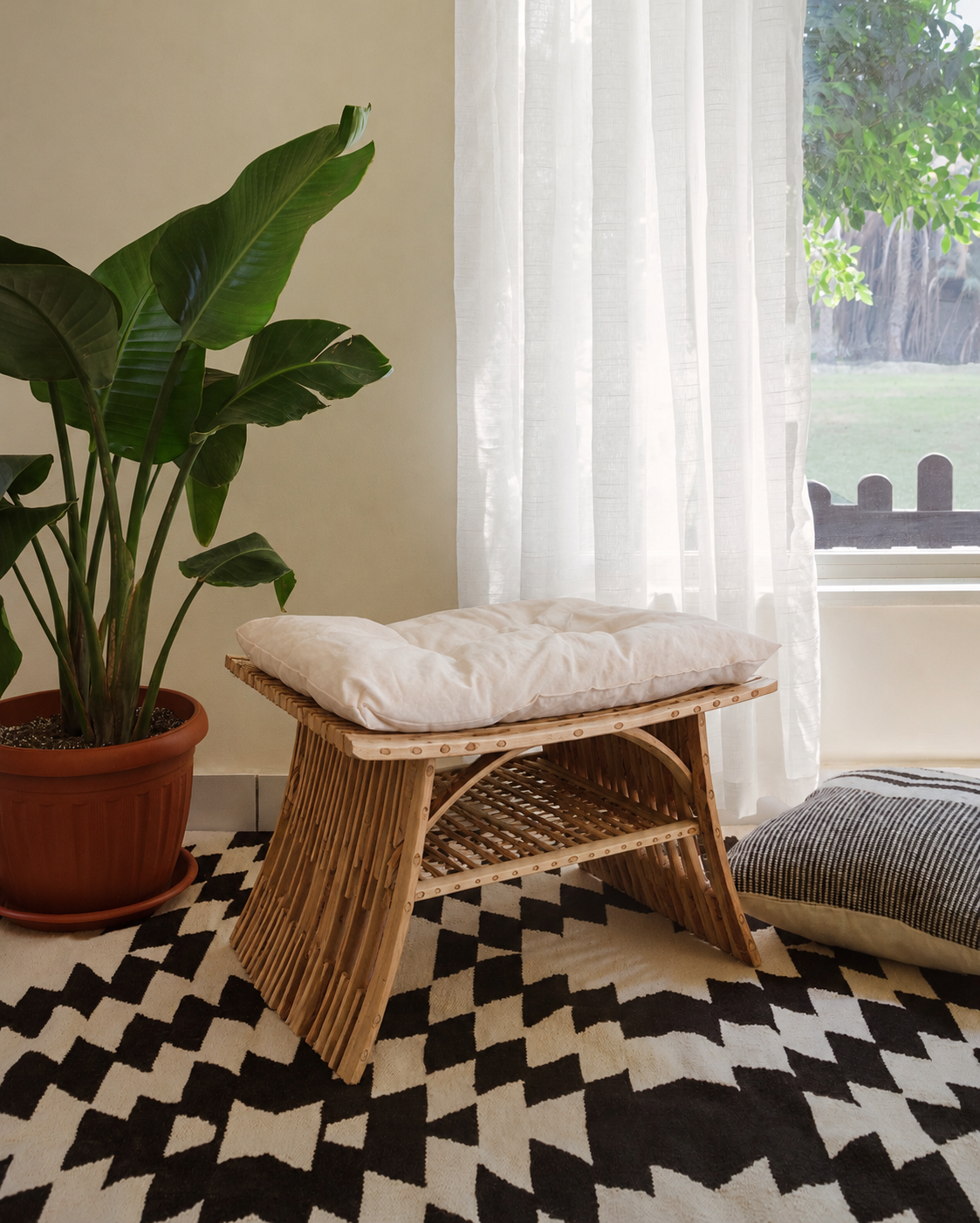 Al-Nakhaal palm stool used as seating by a sunlit window with a plant and patterned rug - Khoos