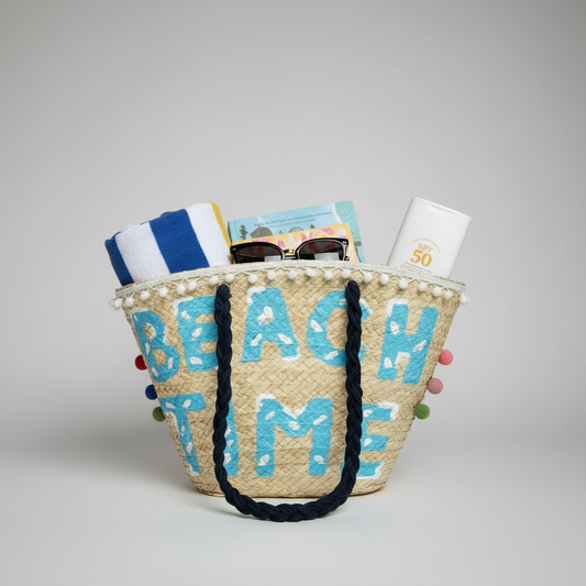 Palm leaf Beach Time tote packed with a rolled beach towel, book, sunglasses and sunscreen, showing how much it holds — Khoos