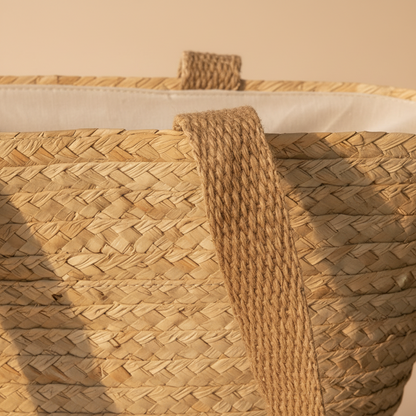 Close-up of the woven handle join, palm strands and white cotton lining on the plain beach tote — Khoos