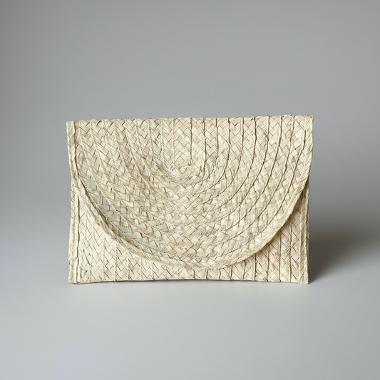 Sana handwoven palm leaf envelope clutch in natural cream, shown alone on a grey studio backdrop — Khoos