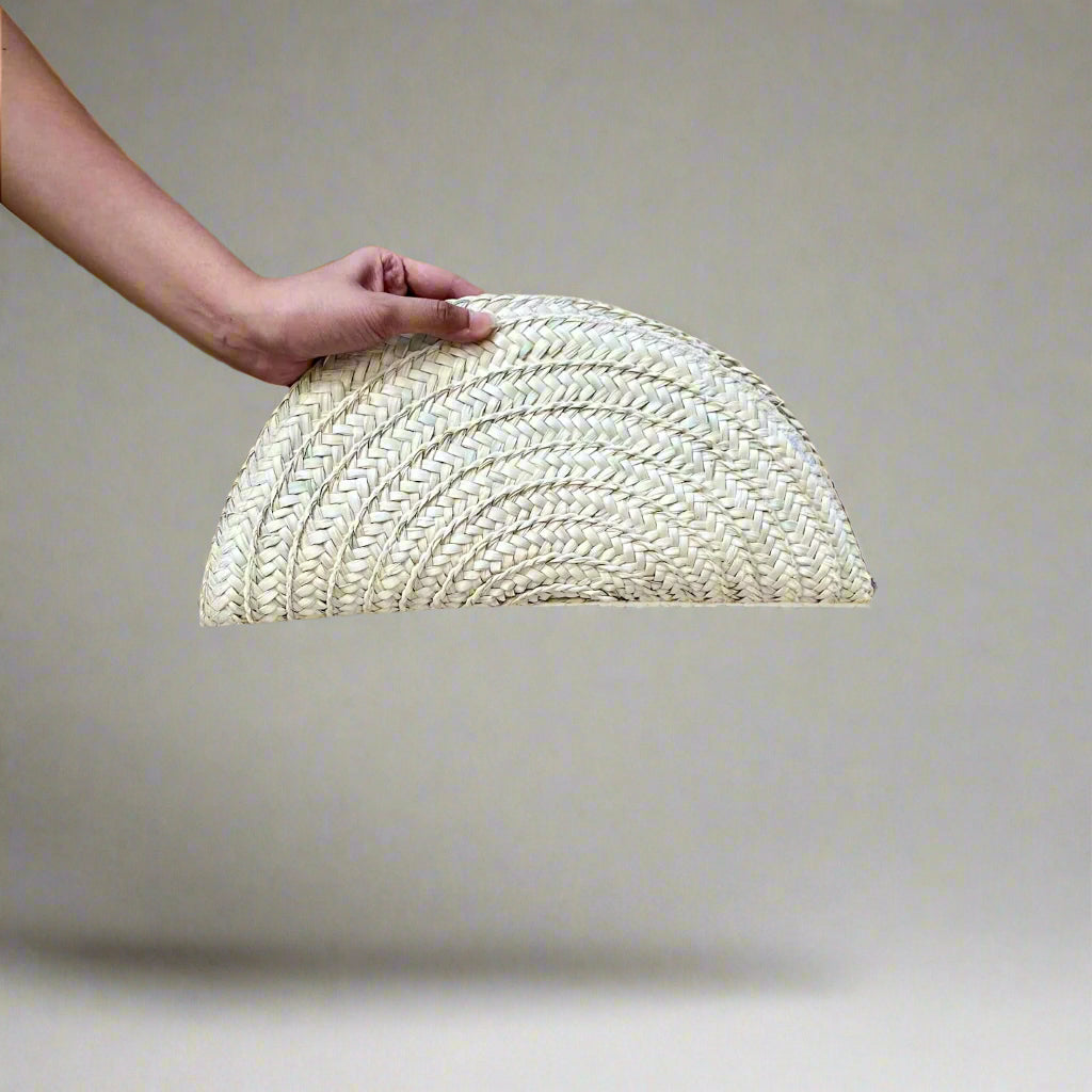 Seashell half moon clutch held in the hand, showing its 38 cm width and scalloped coil rows — Khoos