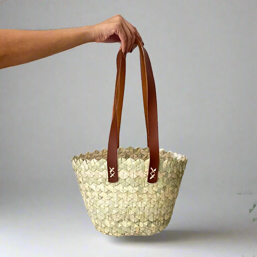 Wavy palm tote held up by its leather handles, showing its shape and 20 cm size — Khoos