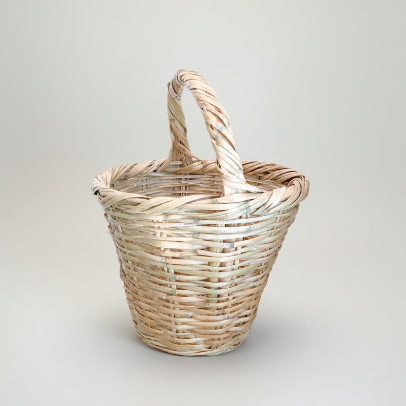 Handwoven palm balcony basket with its arched handle, original studio photograph — Khoos