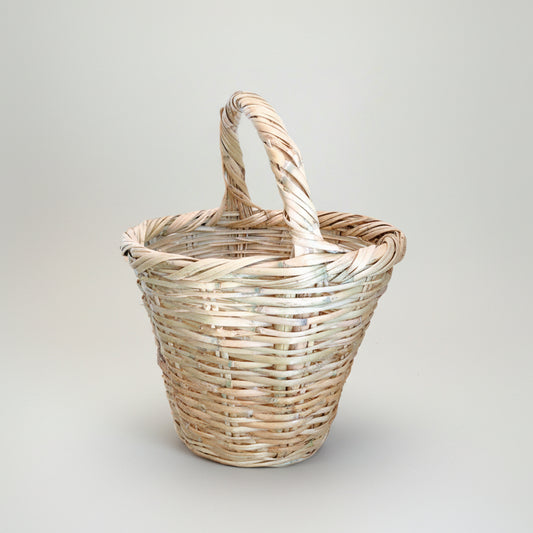 Handwoven palm balcony basket with its arched handle, original studio photograph — Khoos