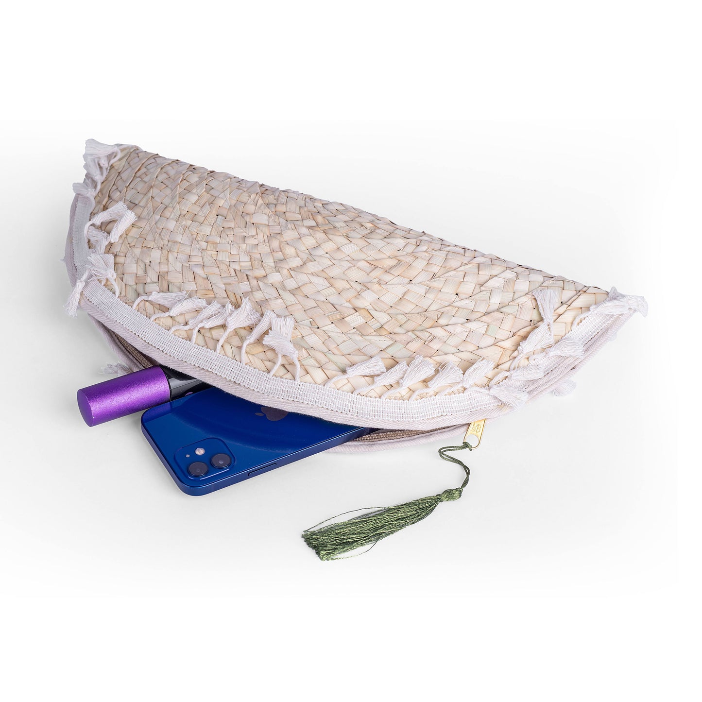 Fringed half-moon clutch open on a white background with lipstick, phone and green tassel spilling out, showing what it holds — Khoos